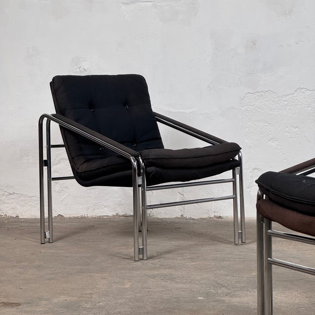 This striking pair of mid-century armchairs embodies the functional elegance of the Bauhaus movement, featuring a...