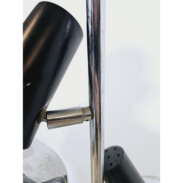 Floor lamp with two adjustable reflectors, made of chrome-plated metal and black plastic. The conical lampshades have a...