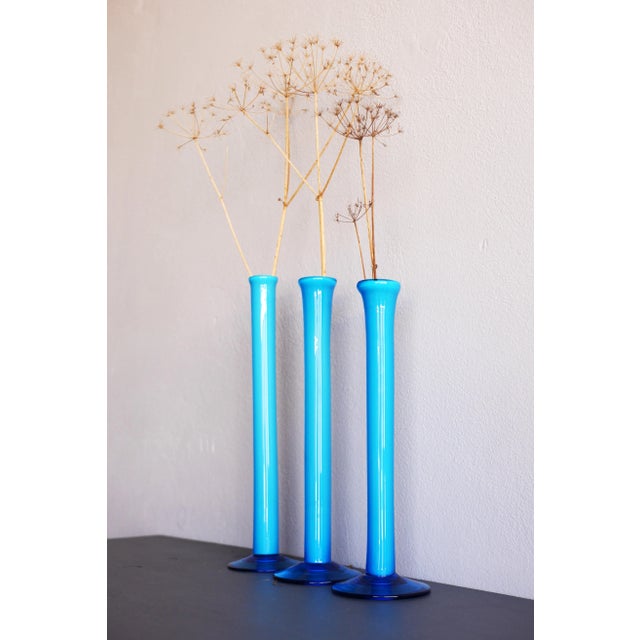 A trio of beautiful tall Orchid vases, all handblown with a fantastic Azure color. These vases are very simple in design,...