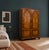 An early 20th-century double wardrobe featuring bookmatched figured walnut veneer, arched moulded door panels and shaped...