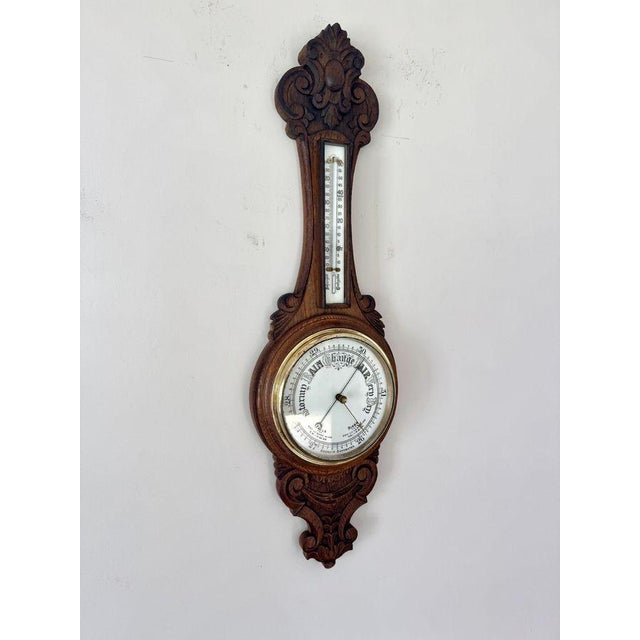 Quality antique Edwardian carved oak aneroid barometer, having a quality antique Edwardian aneroid banjo barometer with a...