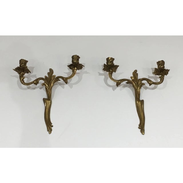 This pair of Louis the 15th style wall lights are made of bronze. This is a French work, circa 1950.
