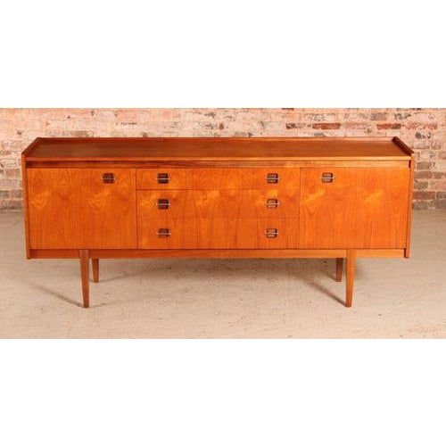 Mid century teak sideboard by wrighton, circa 1960s. A felt lined cutlery drawer and 2 other drawers. 2 cabinet sections....