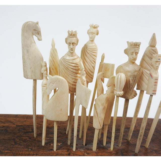19th century collection of french carved bone game pieces. Displayed on primative wood stool or stand. Carved horses,...