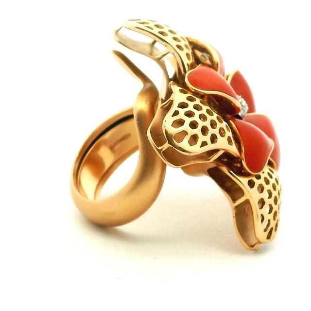 A beautifully sculptural Italian flower ring crafted in 18 karat yellow gold, featuring hand-carved red coral petals...