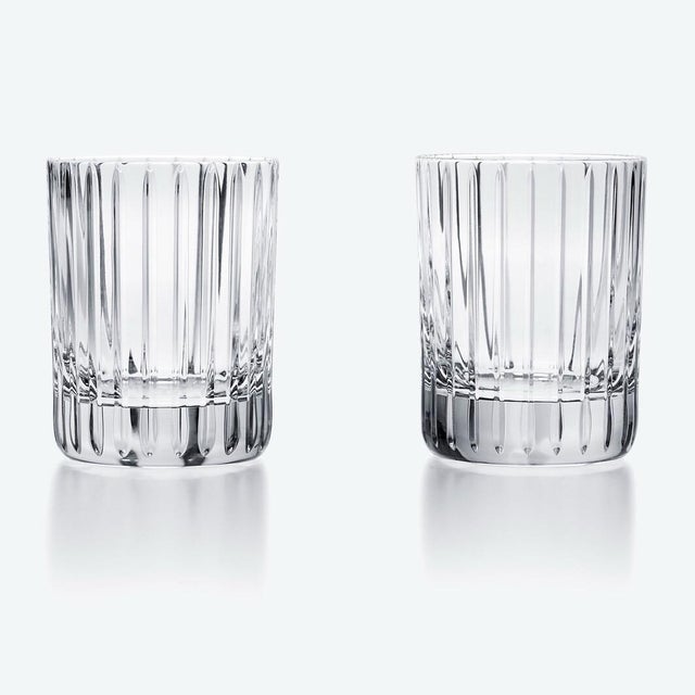 A striking pair of Baccarat Harmonie crystal tumblers featuring the house's celebrated contemporary pattern. Long vertical...