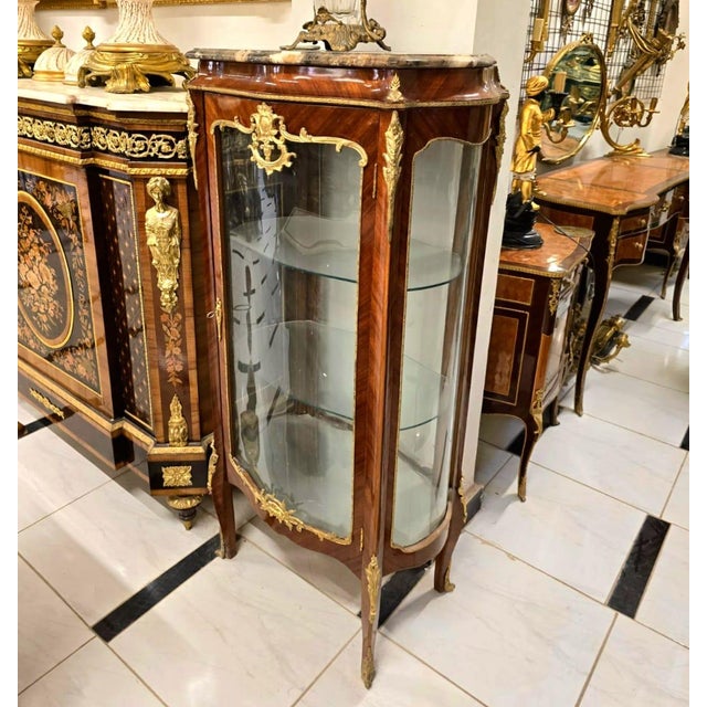 Showcase your most treasured collectibles in this magnificent French Louis XV Curio Display Cabinet, a luxurious statement...
