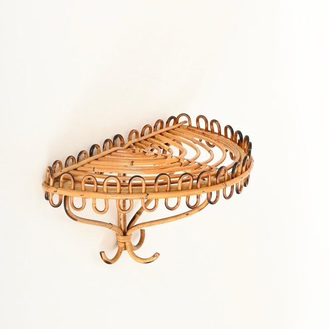 Gorgeous mid-century wall shelf crafted from curved rattan and bamboo. This elegant organic piece was designed by franco...