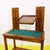 Wooden vanity table featuring a mirror and a green fabric top.