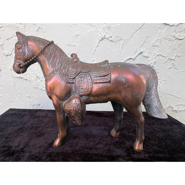 This early 20th century decorative horse coin bank is crafted from cast metal and features finely modeled details,...