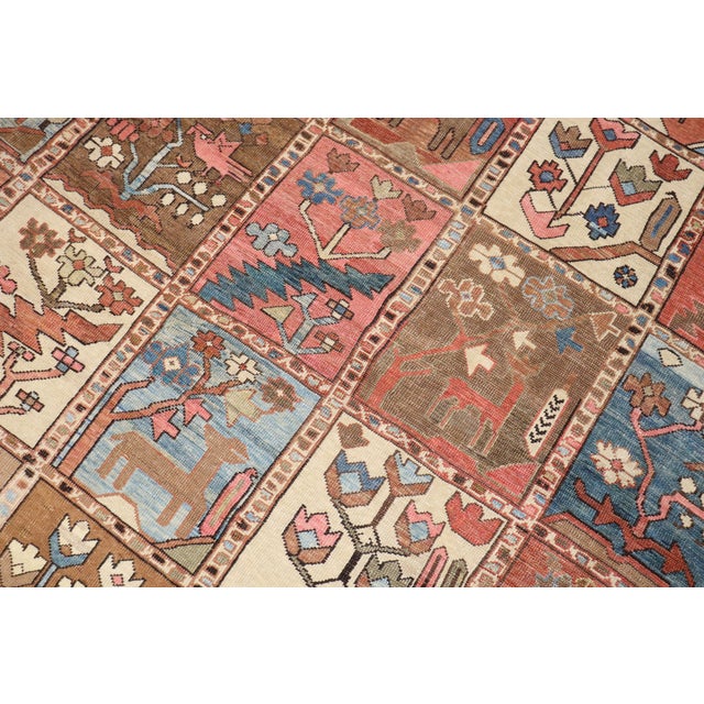 An early 20th Century Persian Heriz rug with a pictorial garden box all over pattern in rustic brown, camel, ivory, pink,...