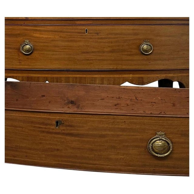 A handsome early 19th-century English bow front chest of drawers, finely crafted from mahogany and distinguished by...