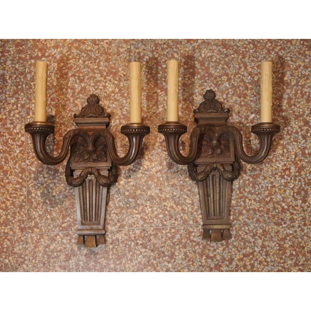 A pair of French Neoclassical patinated bronze 2 arm sconces. Bronze acanthus swag draped over a fluted bracket, fluted...