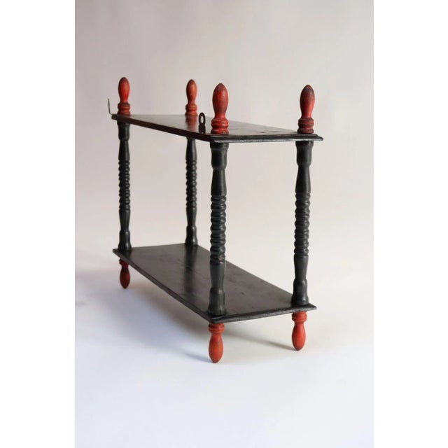 Charming display shelf composed of a carved wooden frame retaining its original black lacquer with elegant red...