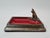 A unique, decorative vide-poche tray made of metal, featuring a striking, hand-sculpted bulldog made of bronze. The piece...