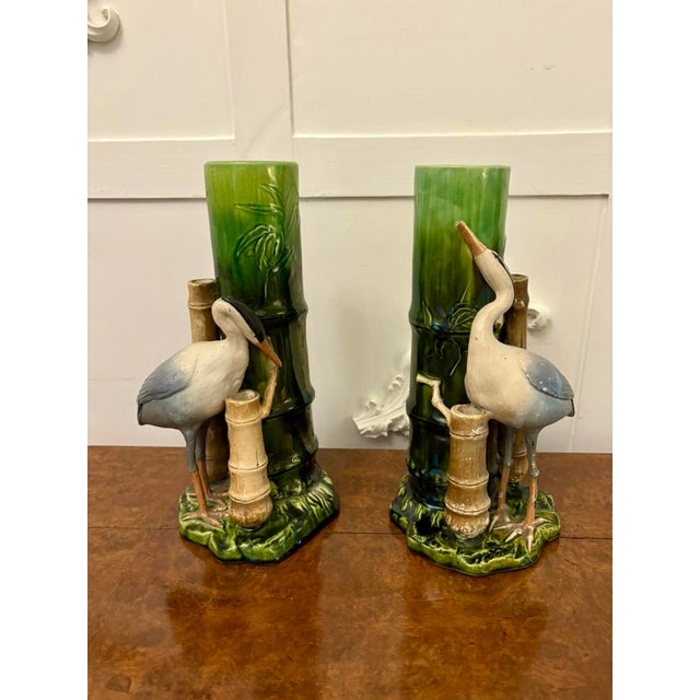 Unusual pair of antique Victorian quality Bretby vases having a quality crane bird standing on a green grass base next to...