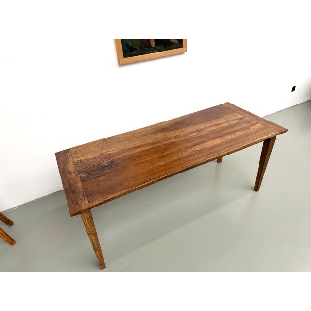 Maison Lecan presents this charming 1950s farmhouse table, featuring an elegant, fully restored solid walnut top. The top...