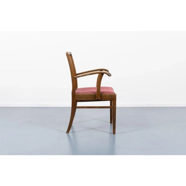 Mid-Century armchairs with sculptural stained wood frame and fabric seat upholstery. Designed by Frits Henningsen in...