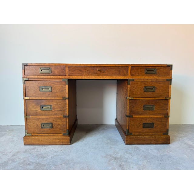A timeless vintage campaign-style walnut desk by Milling Road, a division of Baker Furniture, blending refined...