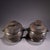 This is a matching pair of cast bronze lidded vessels, featuring a rounded, bulbous body and a domed cover with a central...