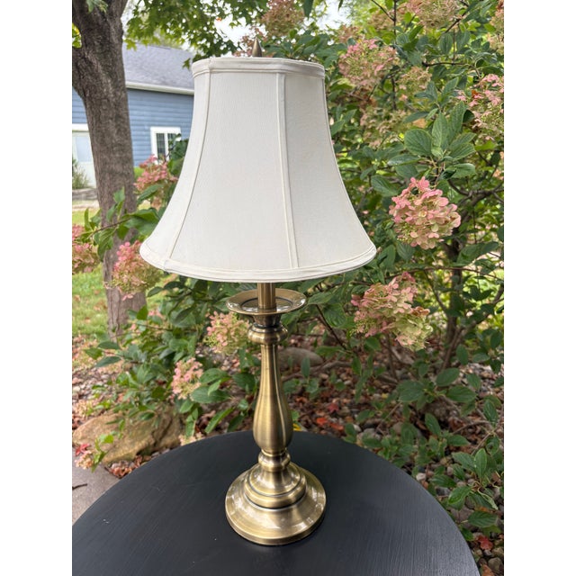 Classic vintage Stiffel table lamp featuring a warm brass-finished metal base with an elegant turned silhouette and tiered...