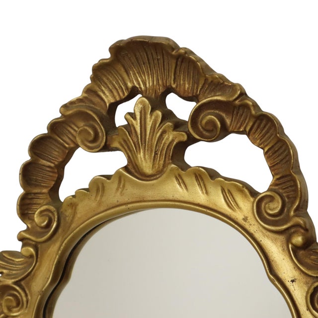 Mid-century crest mirror in a classic gold resin frame, Hollywood Regency style, France, second half of the 20th century....