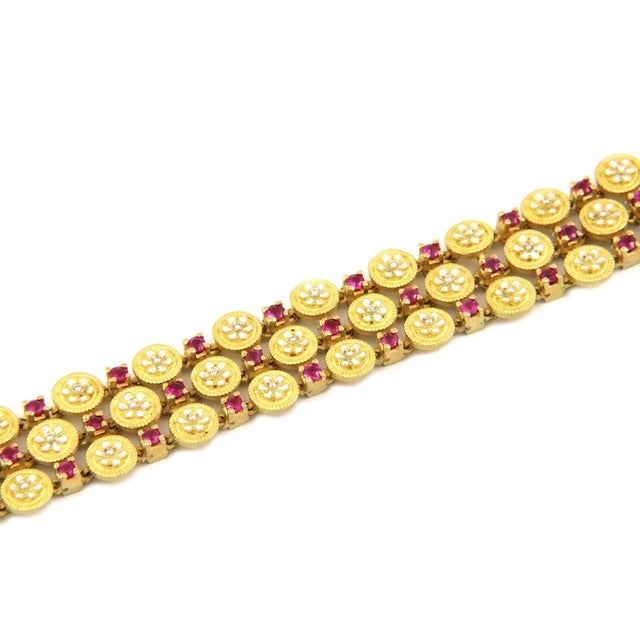 This charming Estate bracelet is crafted from 18k yellow gold featuring triple rows with small round button links and...