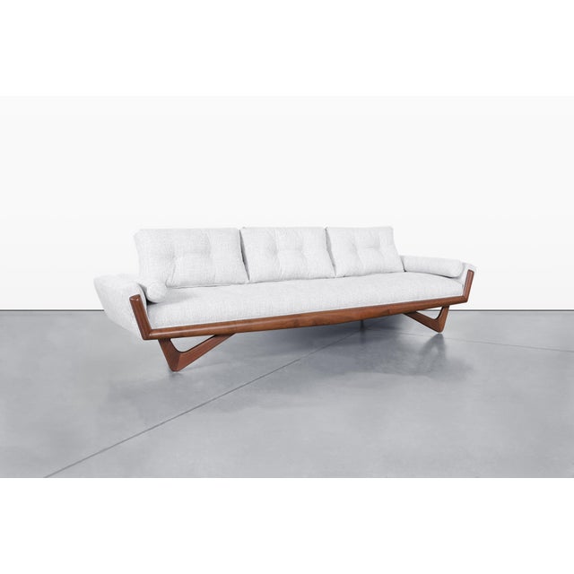 The vintage walnut "Gondola" sofa, designed by Adrian Pearsall for Craft Associates in the 1960s, is a stunning piece that...