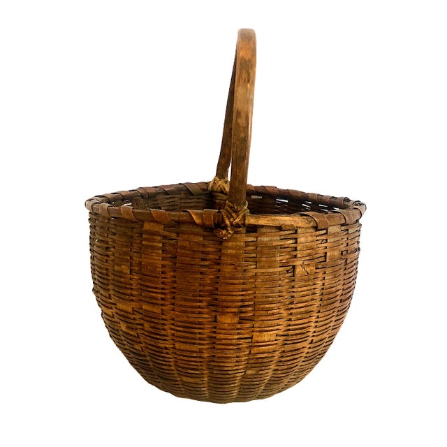 On offer is an antique, hand-woven American utilitarian gathering basket, dating from the late 19th century to the early...