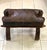 This is a dark-chocolate colored, hand-tooled, embossed, leather cushion on top of a richly stained, Egyptian camel...