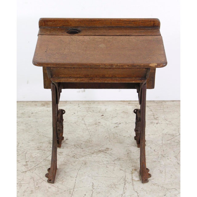 Antique school row desk with dark tone wood desk and seat on industrial style cast iron legs. Both the seat and desk can...