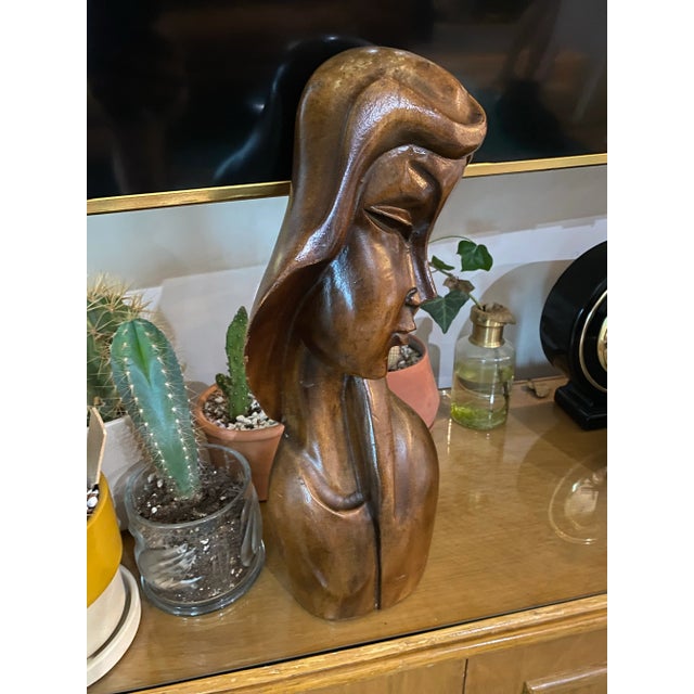 This striking mid-century modern sculpture captures the stylized elegance of a woman in profile, rendered in smooth, hand-...