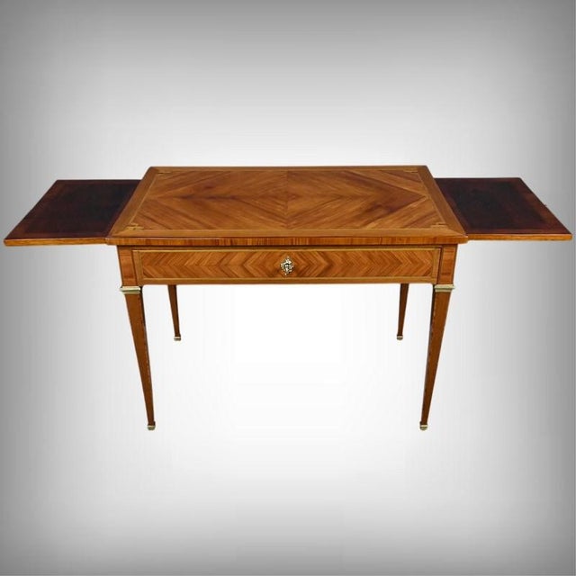 A louis xvi style writing desk, crafted from wood marquetry. The top features a superb rosewood veneer arranged in a...