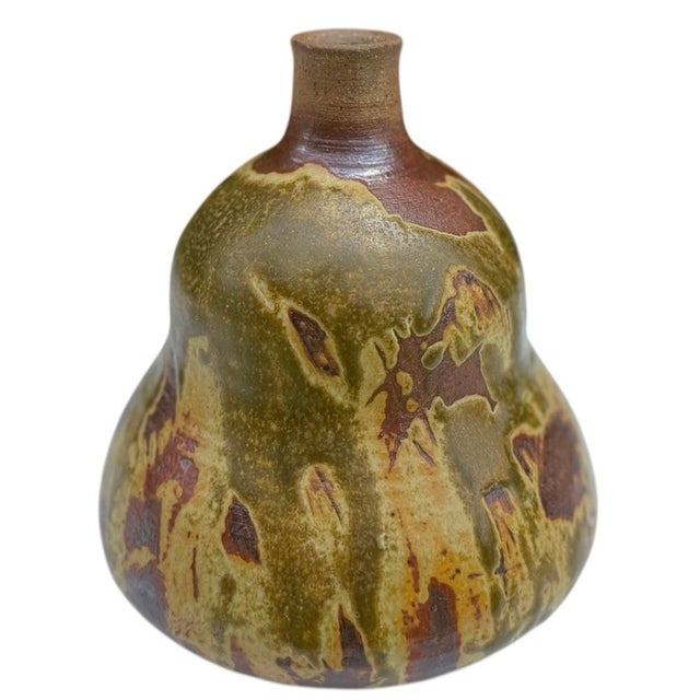 A beautifully handcrafted signed studio pottery bottle vase featuring an organic bottle form finished in richly layered...