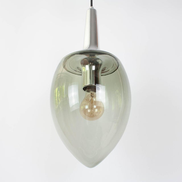 Elegant and sculptural, this vintage Peill & Putzler pendant lamp was produced in Germany during the 1960s and is a...