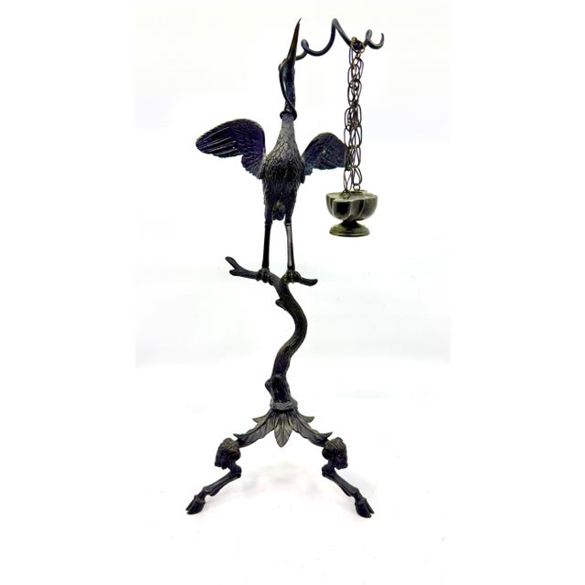 A beautifully patinated bronze Neo Classical Grand Tour souvenir oil lamp with a heron holding up the oil lamp. This...