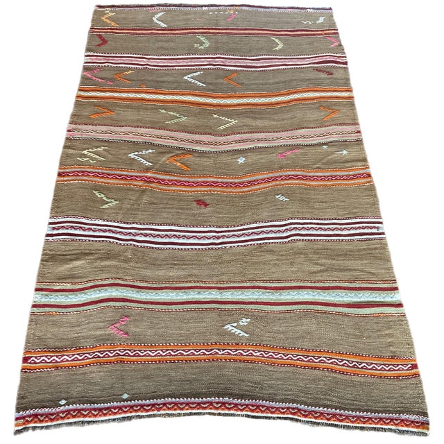 A beautiful vintage kilim, handwoven in central Turkey circa 1960 featuring a traditional, multicoloured banded design in...