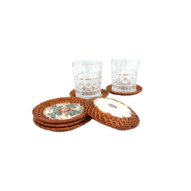 A striking set of 6 Bat Trang coasters combines a hand-painted ceramic center with a richly textured, warm-toned woven...
