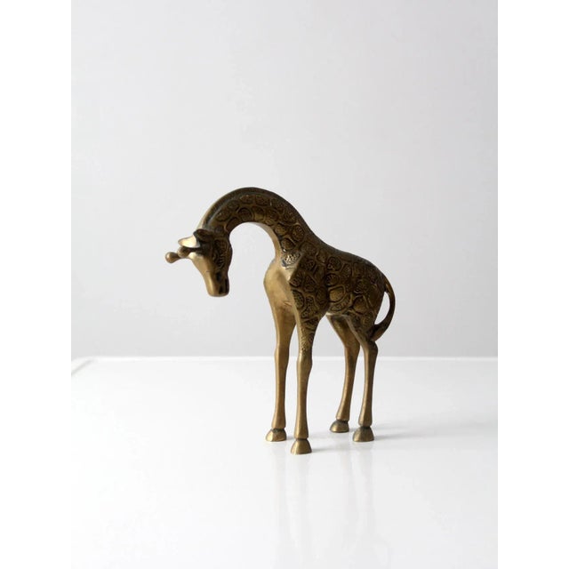 This is a mid-century brass giraffe figurine. The solid brass giraffe has a lowered head stance with nice detailing of...
