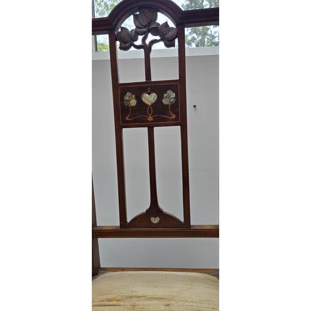 Beautiful antique Edwardian armchair crafted from rich mahogany and featuring elegant Arts & Crafts–style detailing with...