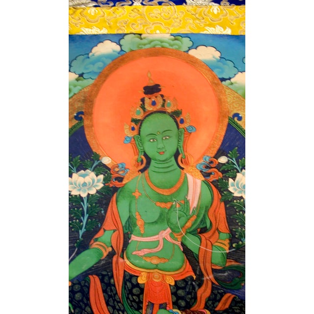 Chinese painted thangka of Bodhisattva Green Tara on silk and gold silk brocade, sheer gold silk backing. Circa Republic...