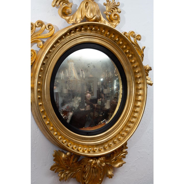 This is an exceptional 19th century water-gilded Continental convex mirror with a bold, prominent eagle situated above a...