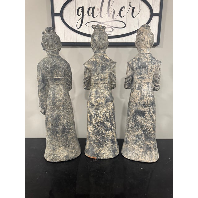 Elegant set of three Asian-inspired figurative statues by Maitland-Smith. These sculptural figures feature traditional...