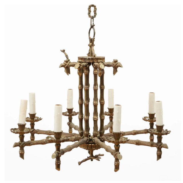 A vintage Hollywood Regency style eight light chandelier in bronze faux bamboo form. The chandelier features eight...