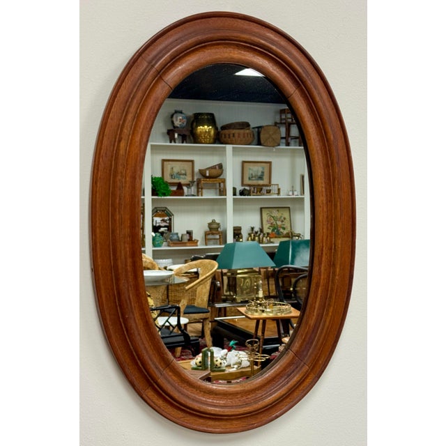 Vintage oval farmhouse style wood framed wall mirror. Features nice, rich natural wood tones with beveled frame. Age wear....