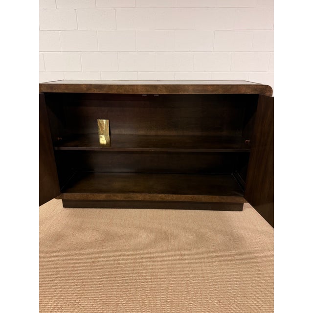 Beautiful Burled Console from Mastercraft with Brass inset trim and two doors concealing plenty of storage. This is a trim...