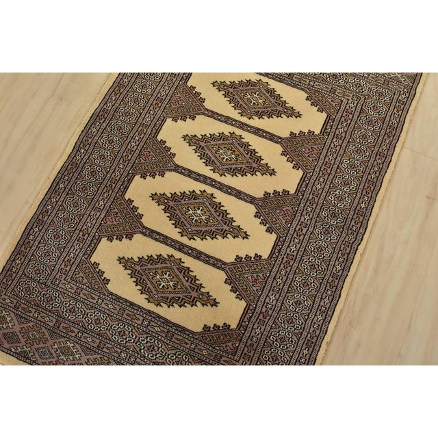 A tribal Bokhara Jaldar rug hand-knotted with fine wool on a cotton foundation. This rug features geometric medallions set...