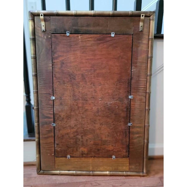Elegant vintage bamboo wall mirror featuring a beveled glass center and a refined matte gold finish. This piece has been...