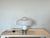 A 1970s Brumbury table lamp by Luigi Massoni for Guzzini. The frame is made of white lacquered and chromed metal. The...