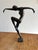 Elegant bronze figure of a nude female dancer balancing gracefully on one foot, arms extended in motion. This piece bears...